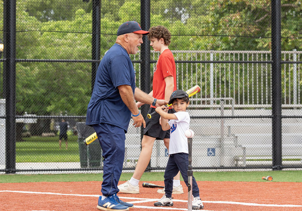 Young child learning to play baseball with a coach