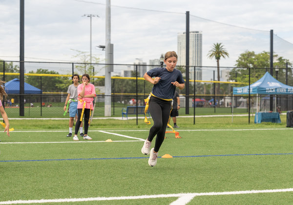 Girl playing flag football on a Miami Beach field