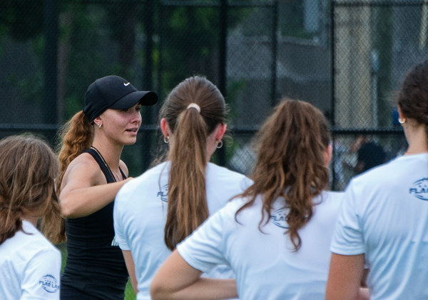 Coach mentoring girls at a flag football session